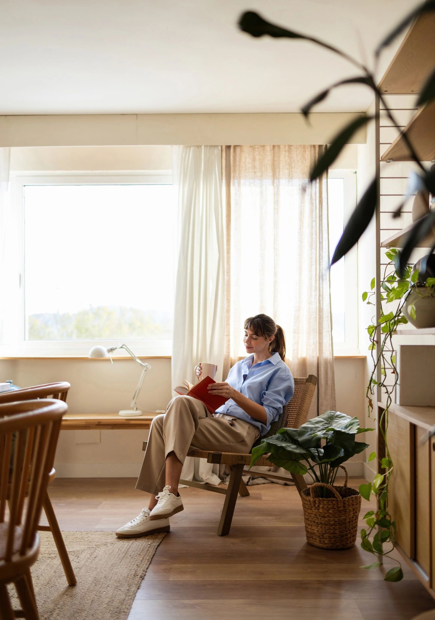 Woman reading by a window in a quiet, reflective moment