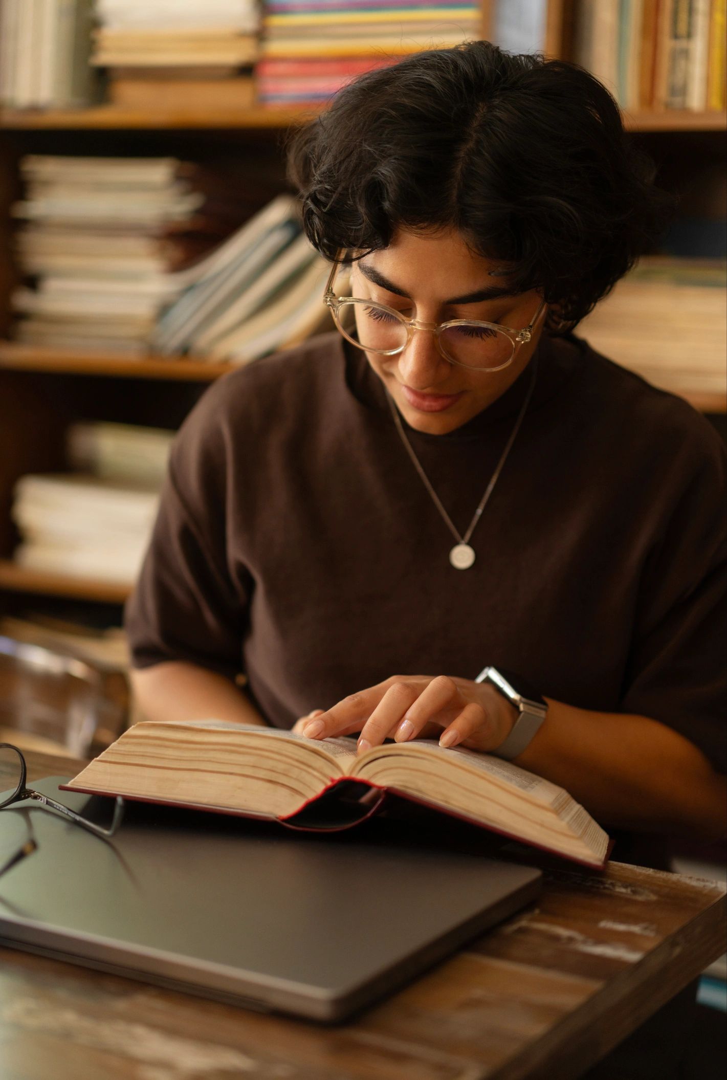 Woman reading thoughtfully in a library